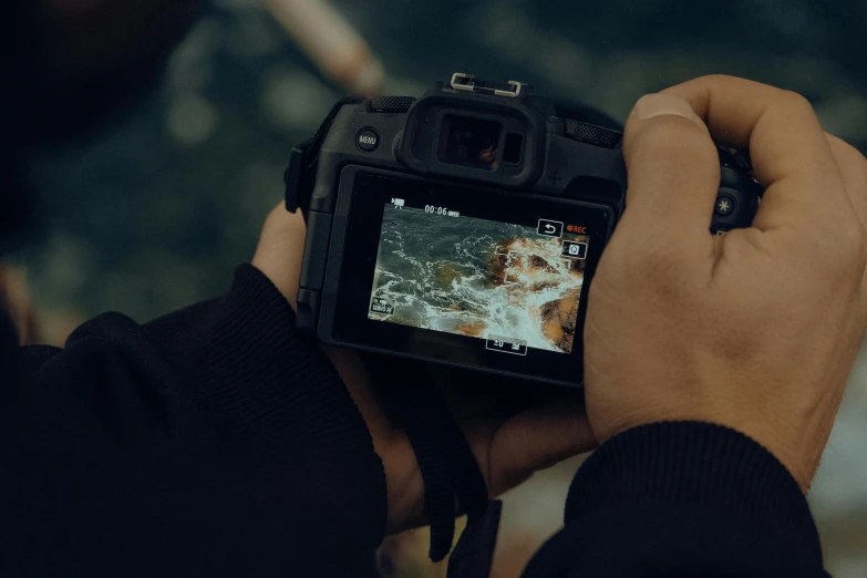 a man holding his camera up looking at soing