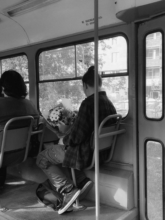 some people sitting on some chairs in a train