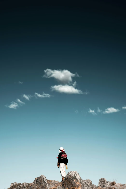 a person standing on rocks while the sky is in the background