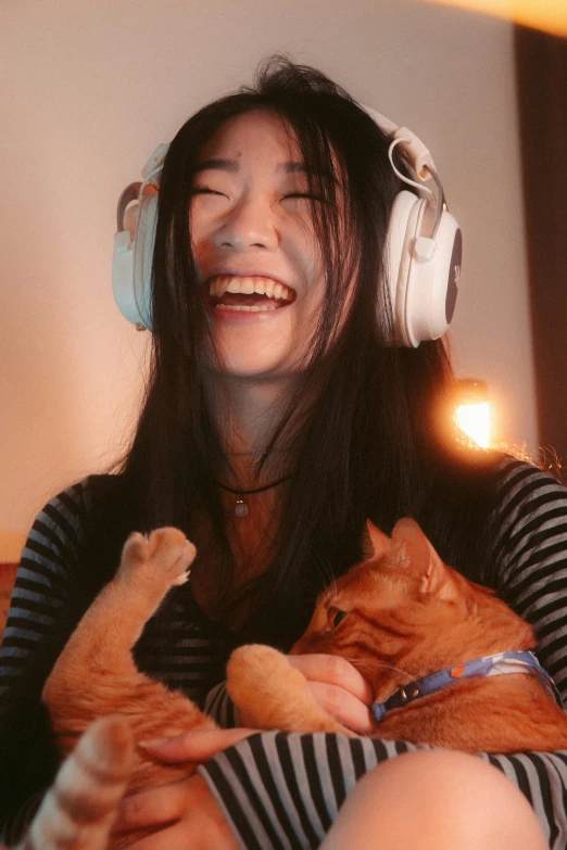 a woman is holding a cat and listening to music