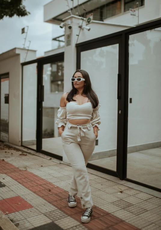 young woman standing on sidewalk in front of store