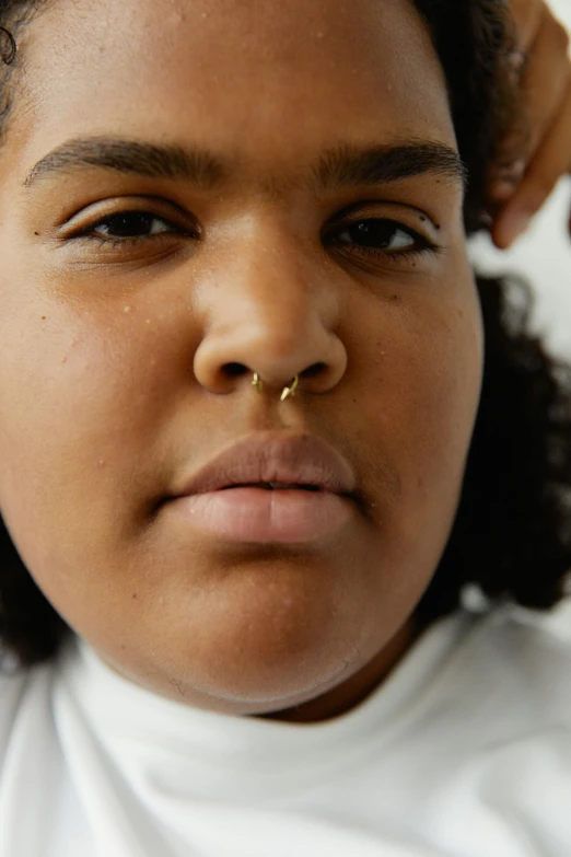 a close up of a girl's nose has an arrow in her nose