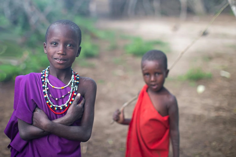 two young children, one in an orange dress and one in pink