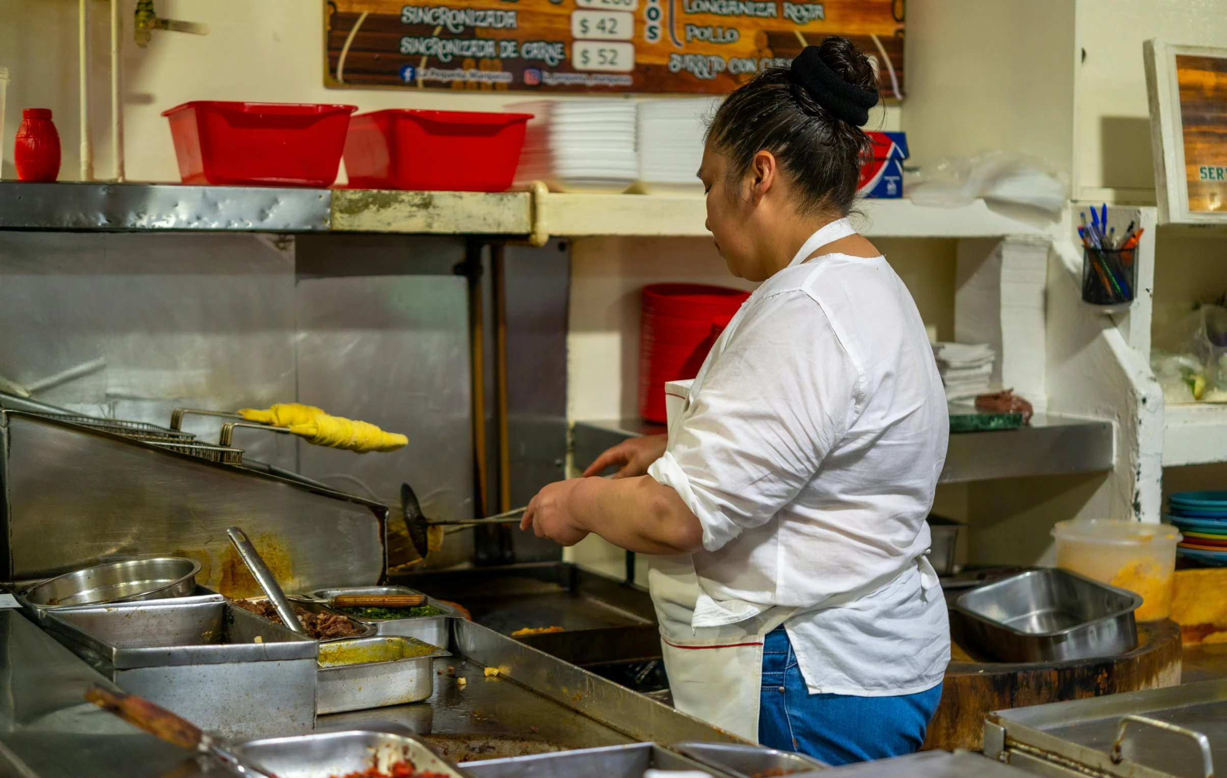 a woman is cooking in a restaurant kitchen