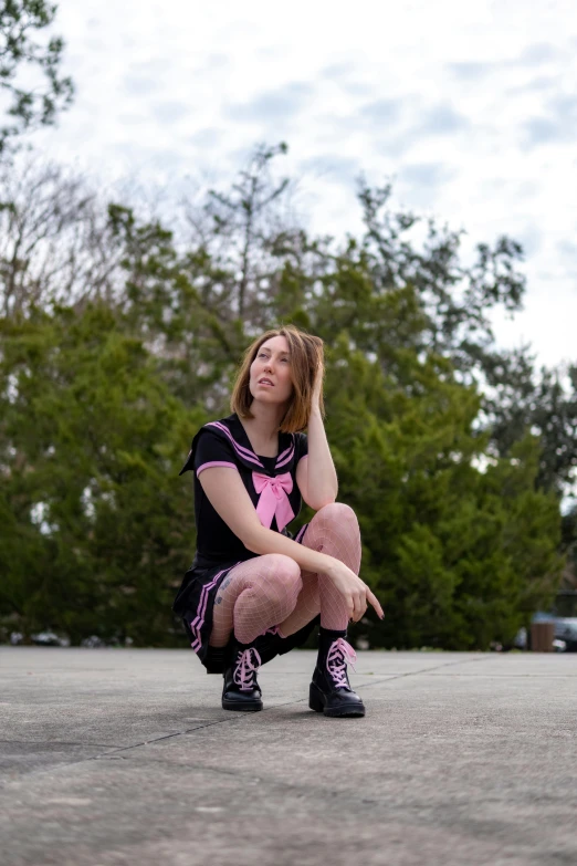 a woman sitting on the ground holding her leg while wearing pink tighties