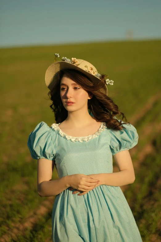 a woman in a green dress is standing outside