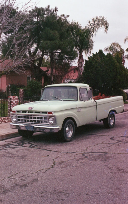 a vintage white truck sits on the street