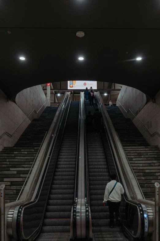 a man rides an escalator down the steps