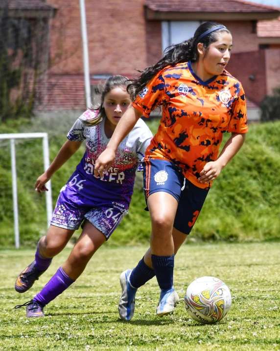 two girls are playing soccer against each other