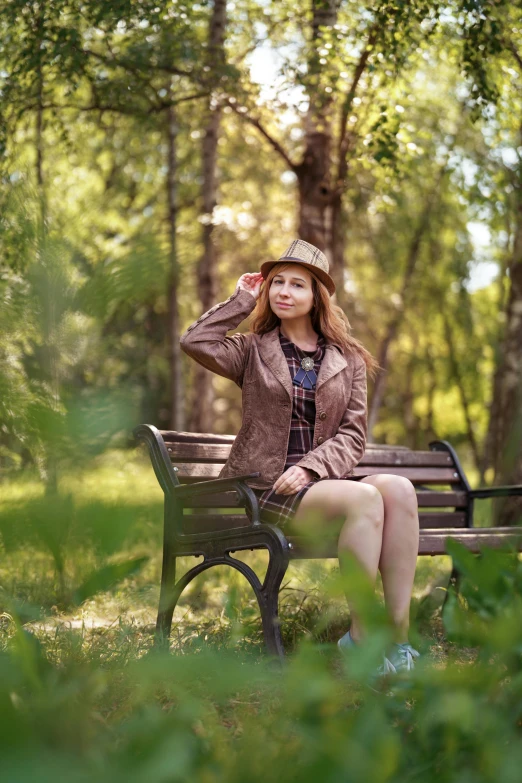 a woman sitting on top of a bench in the middle of a forest