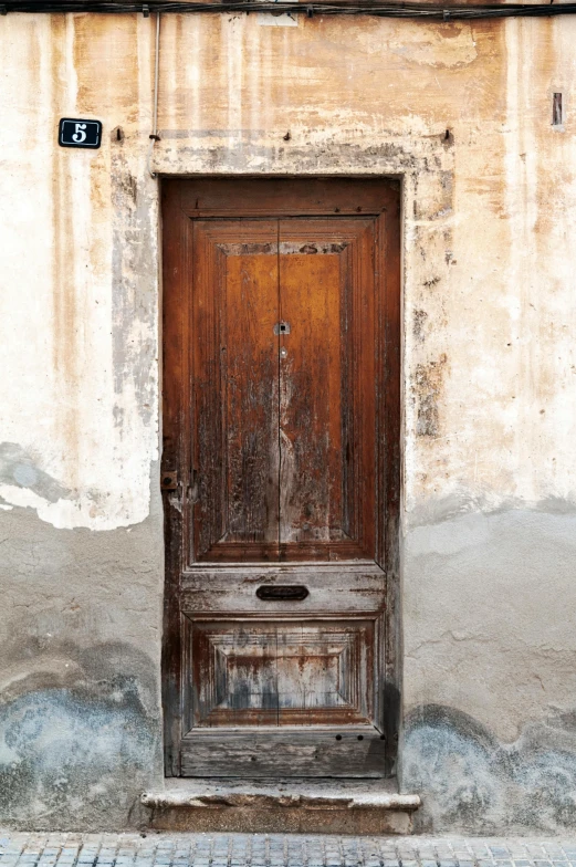 a wooden door sitting next to a brick building