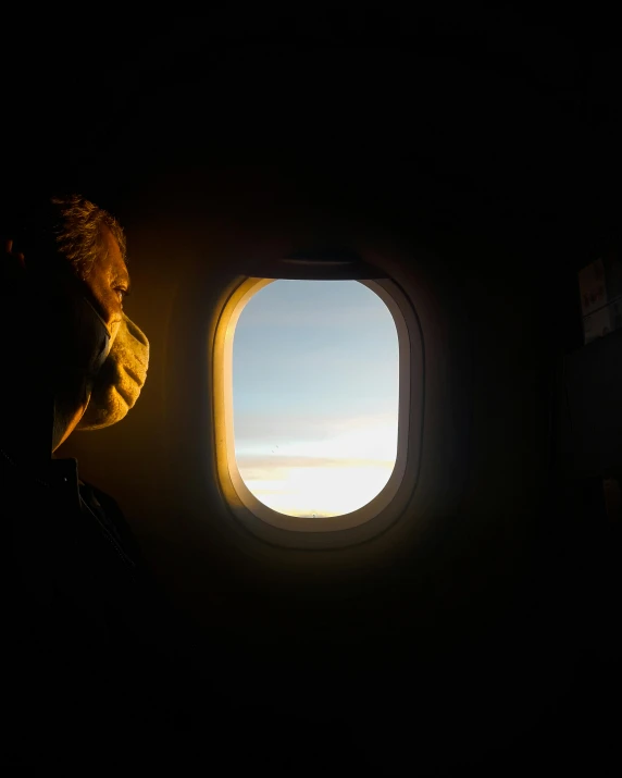 the view from the window of an airplane with a man looking out it