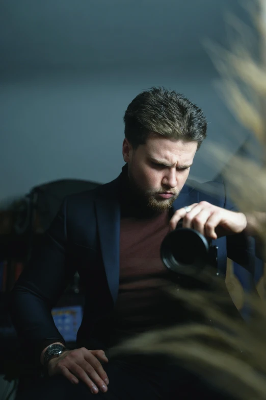 a man sits down while holding his camera