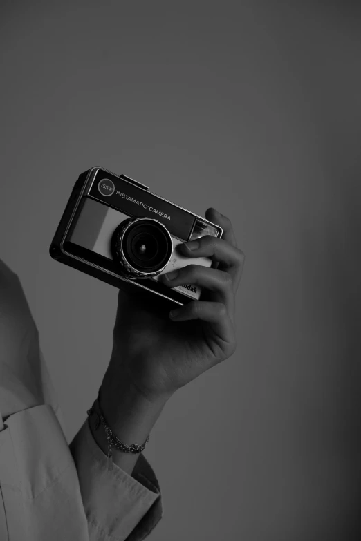 a woman holding a camera up in the air