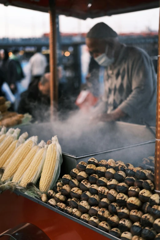 food on a grill being cooked by people outside