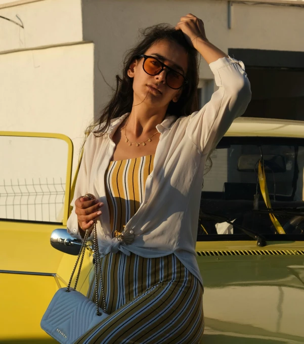 the woman is posing in front of a car