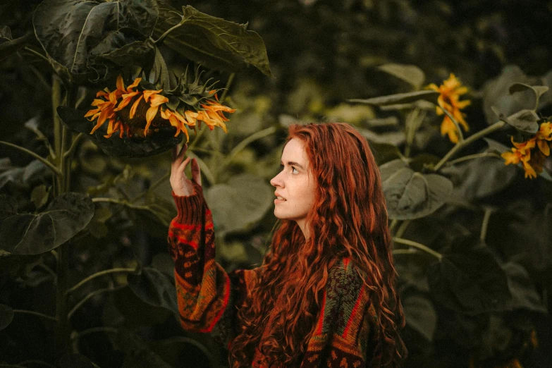 a woman standing next to a field of flowers