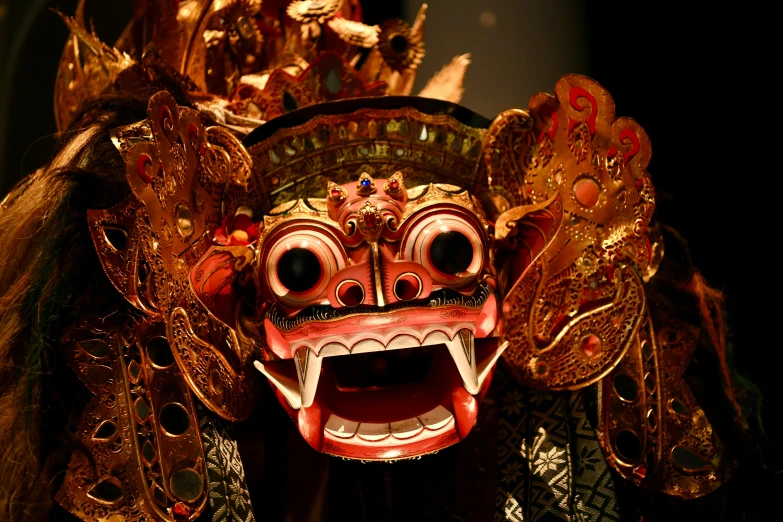 the head and shoulders of a large masked creature with ornate ornaments