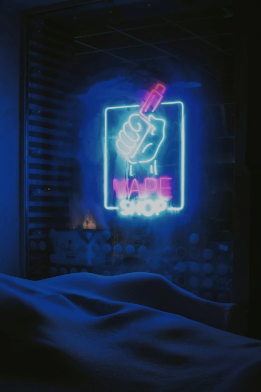 neon sign above a bed with a black background