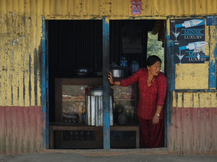 a woman in red dress standing inside of a yellow building