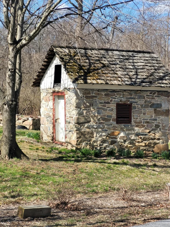 a outhouse sits by the side of the road