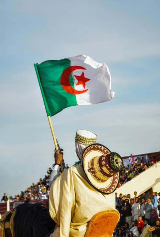 a man is wearing a traditional garb and holding the algerian coat