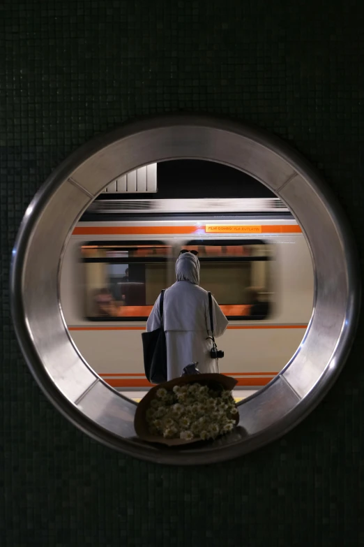 a man walking towards the subway car with luggage