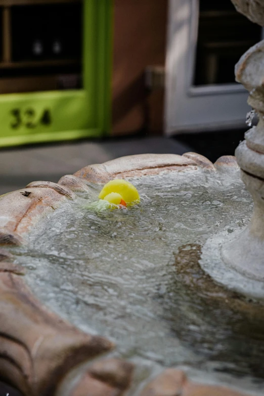 there is a yellow ball stuck in a fountain