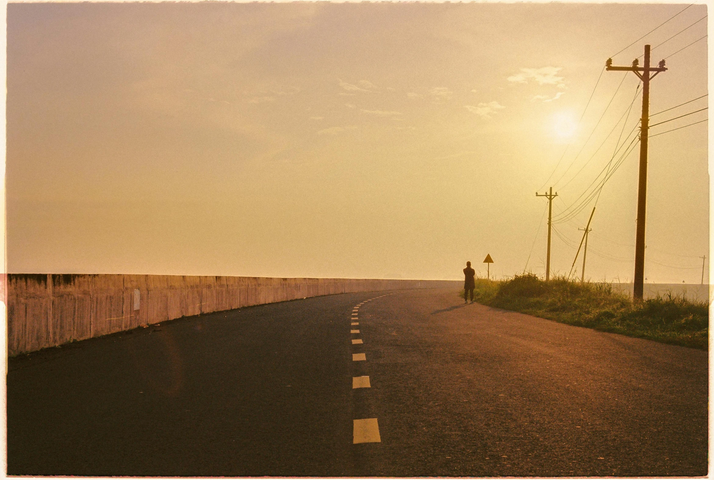 a street with a person standing at the end