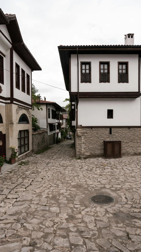 a couple of white and brown buildings some stone walkways and a building