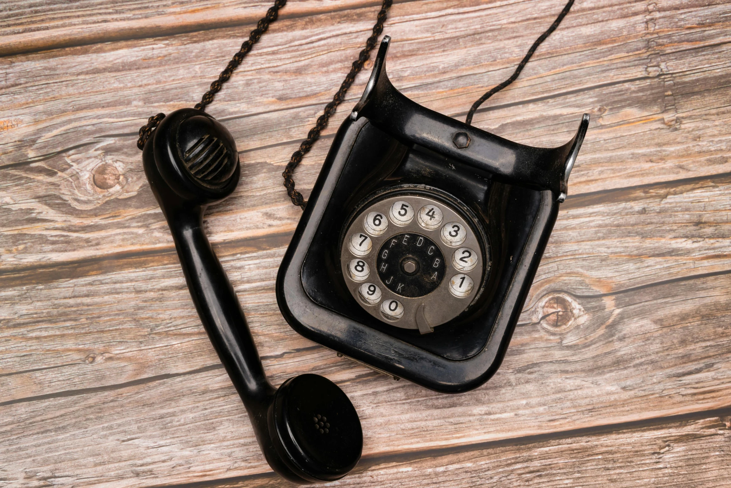 an old fashioned phone sits on a wooden table