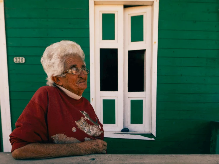 a very older lady looking at soing in front of her house