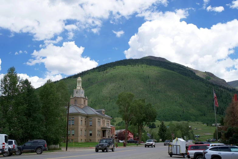 a church steeple sits on a hill in front of a town