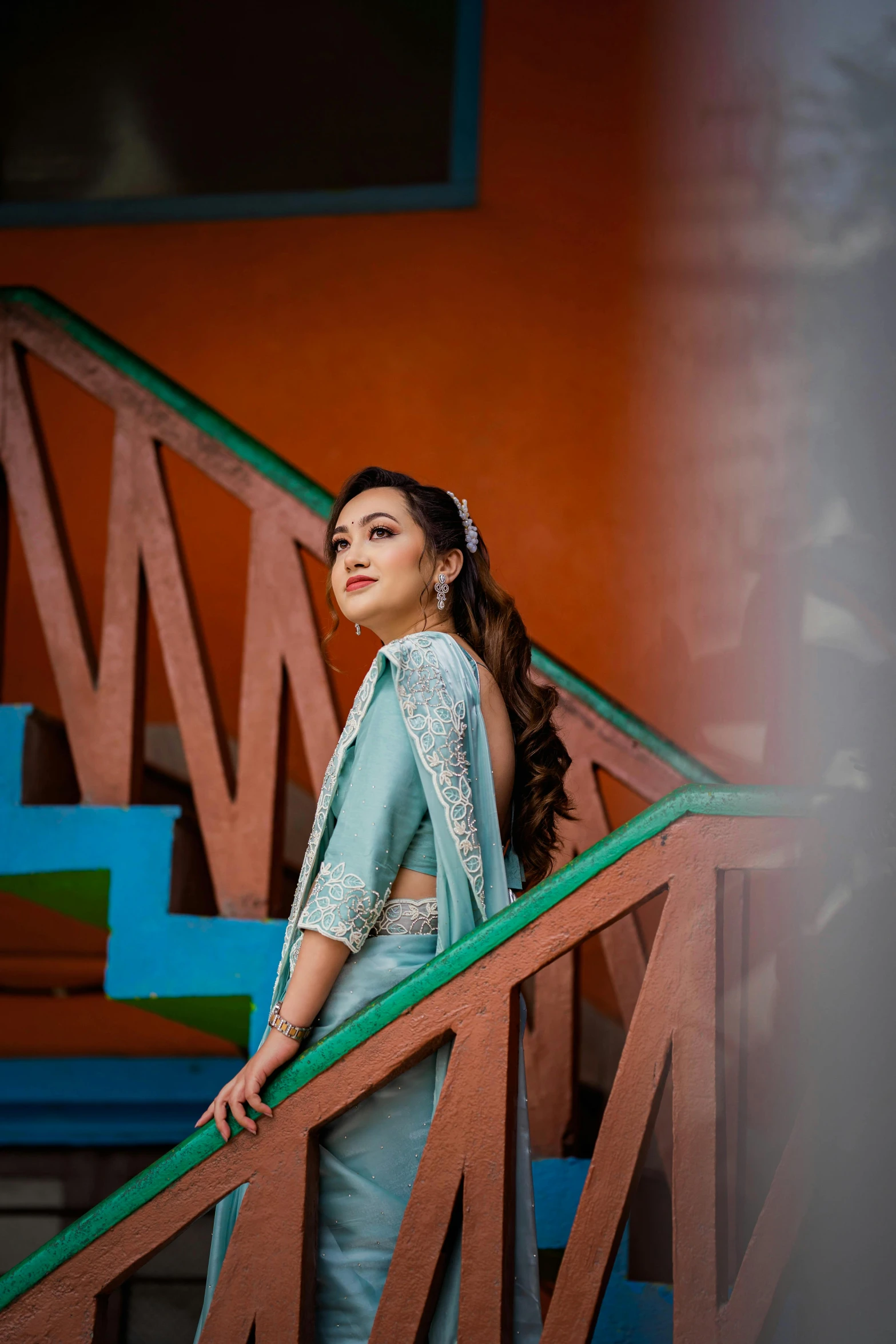 a woman in a long blue dress standing on stairs