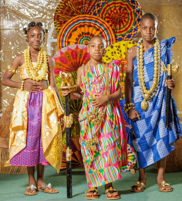 three african woman in traditional clothing, with baskets, and paraphernalia