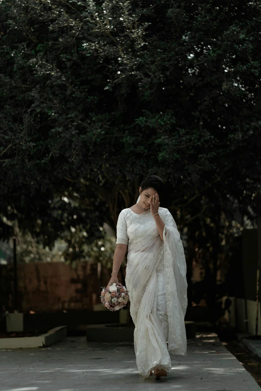 the woman is walking alone in a sari