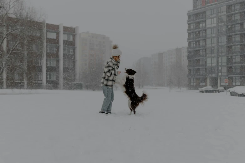 a woman and her dog in the snow