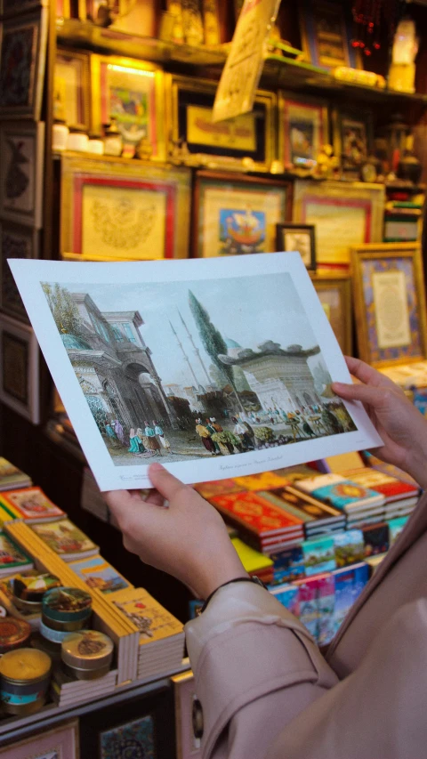 a woman holding up an image in a book