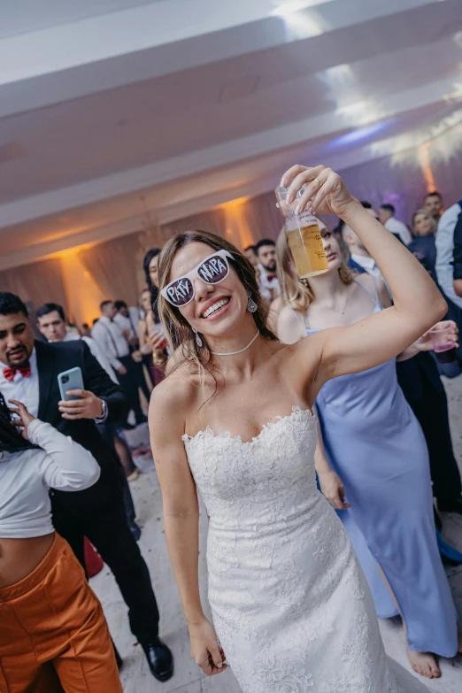 a woman wearing funny sunglasses with a beer