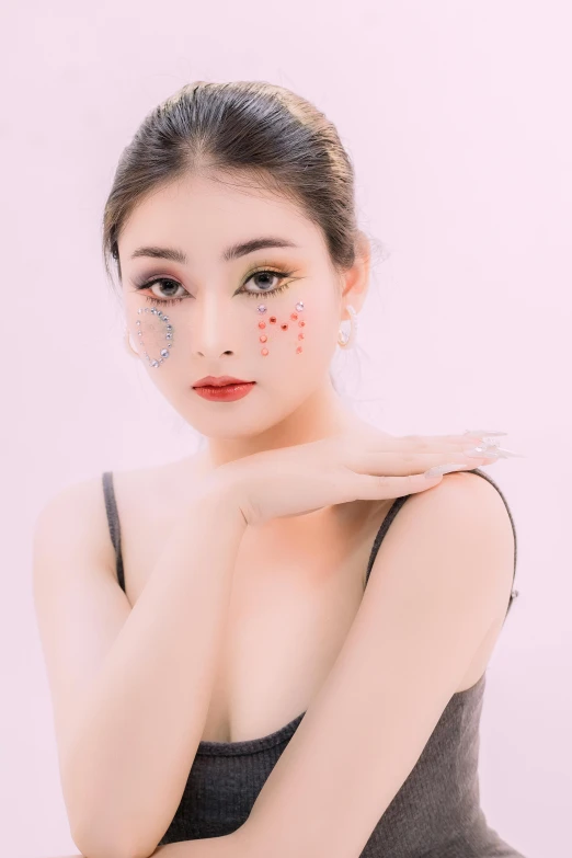 an asian woman wearing black clothes with pink decorations on her face