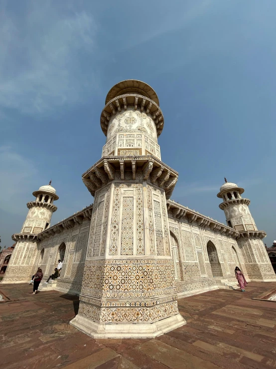 an ornate tower structure sits on a brick walkway