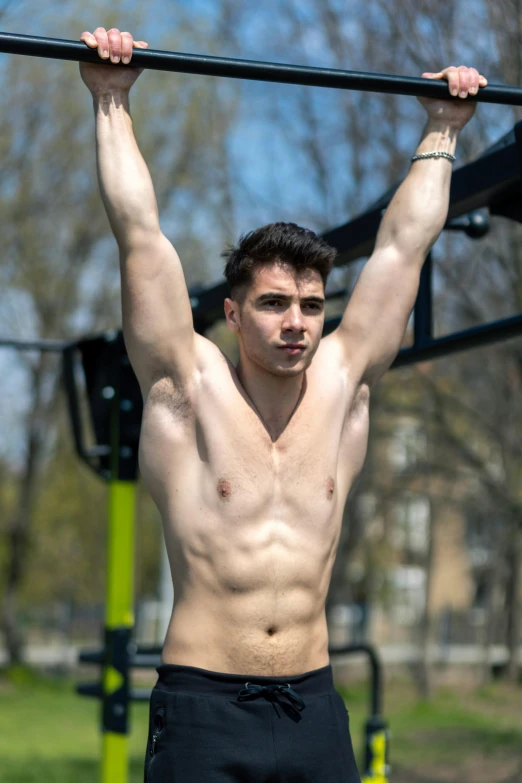 man holding bar above his head and chest at park