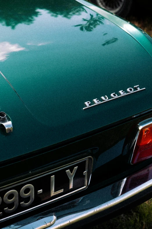 the back end of a green car on a street