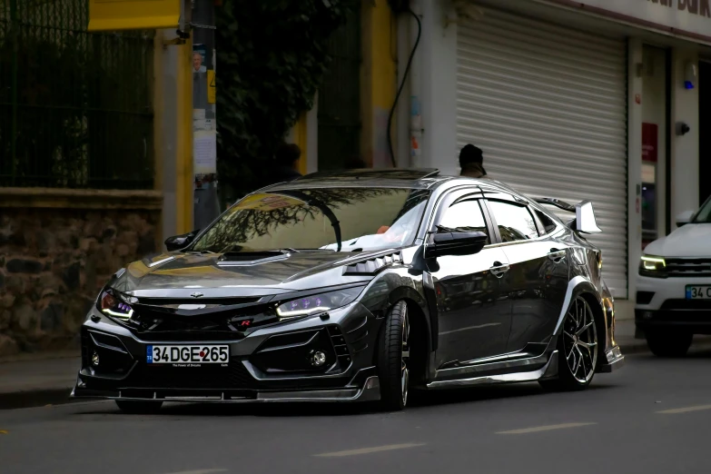 a car with some black rims parked next to a building