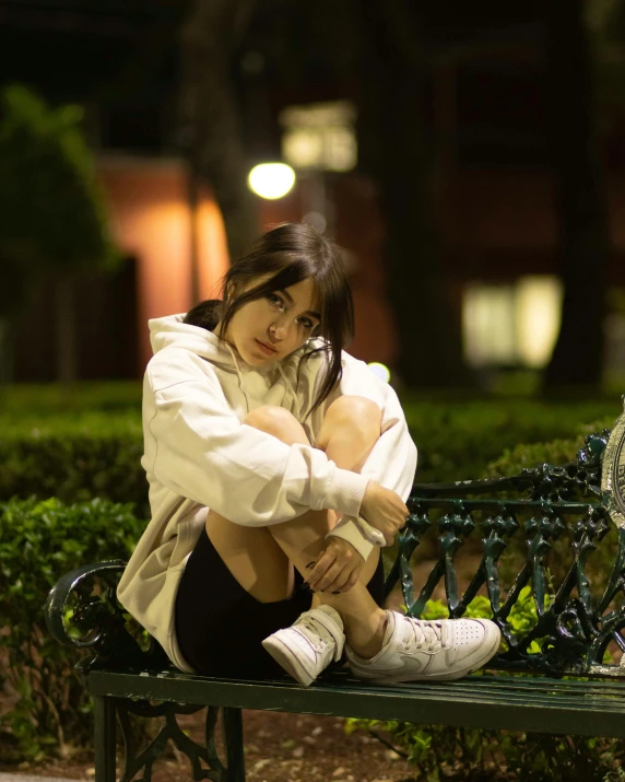 a woman sitting on top of a metal bench