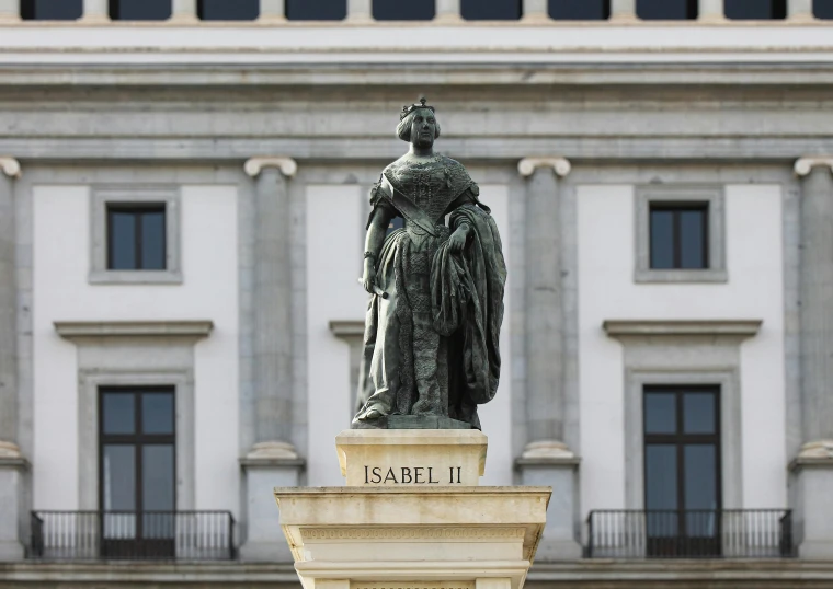 a statue sits in front of a building with large doors