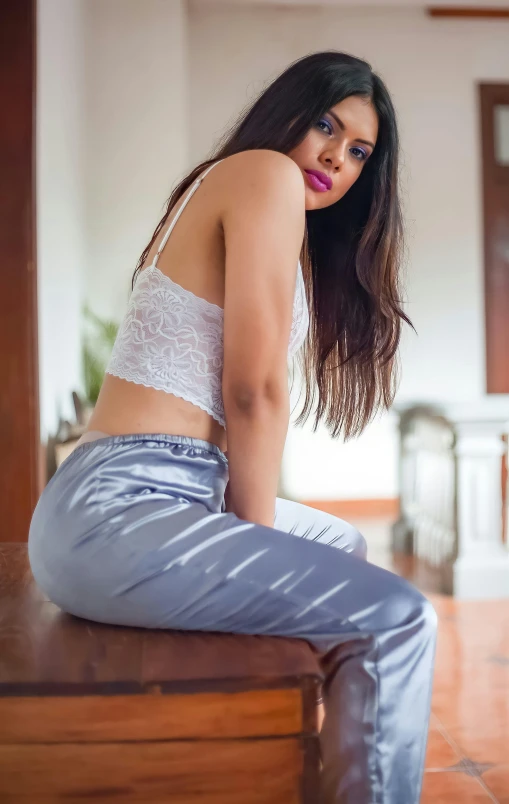 an attractive woman sitting on top of a wooden table