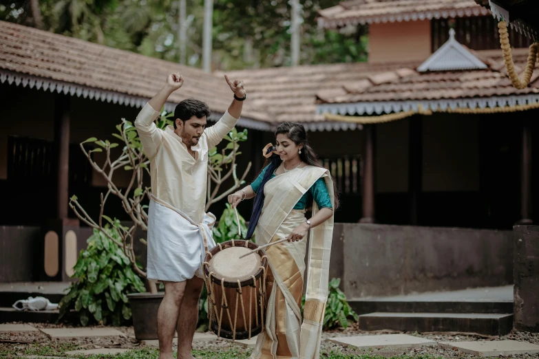 young couple performing folk dance with a large drum