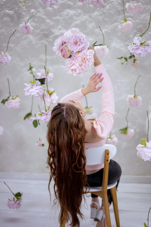 a person sitting on a chair near a bunch of flowers