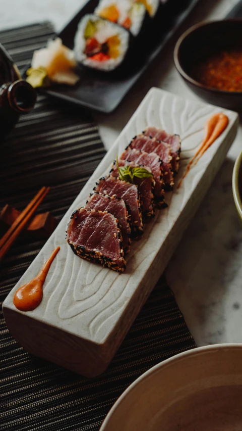 a plate with several meats on it next to other plates